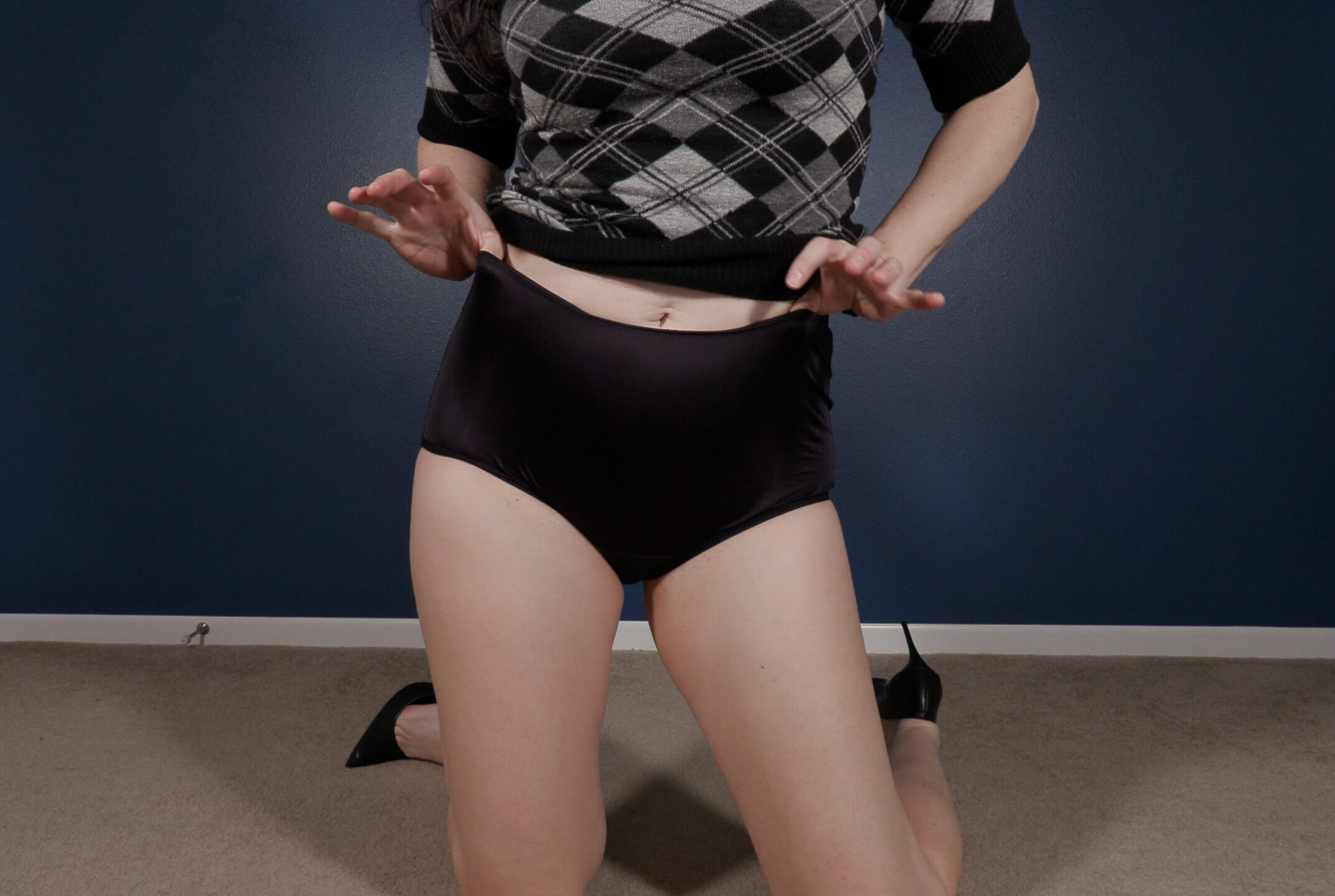 Kylie Jacobsx modeling a pair of black high-waisted satin granny panties.